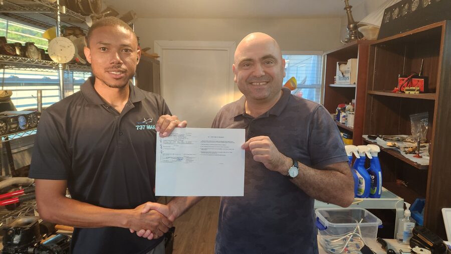 A&P student with instructor holding a freshly earned FAA certificate